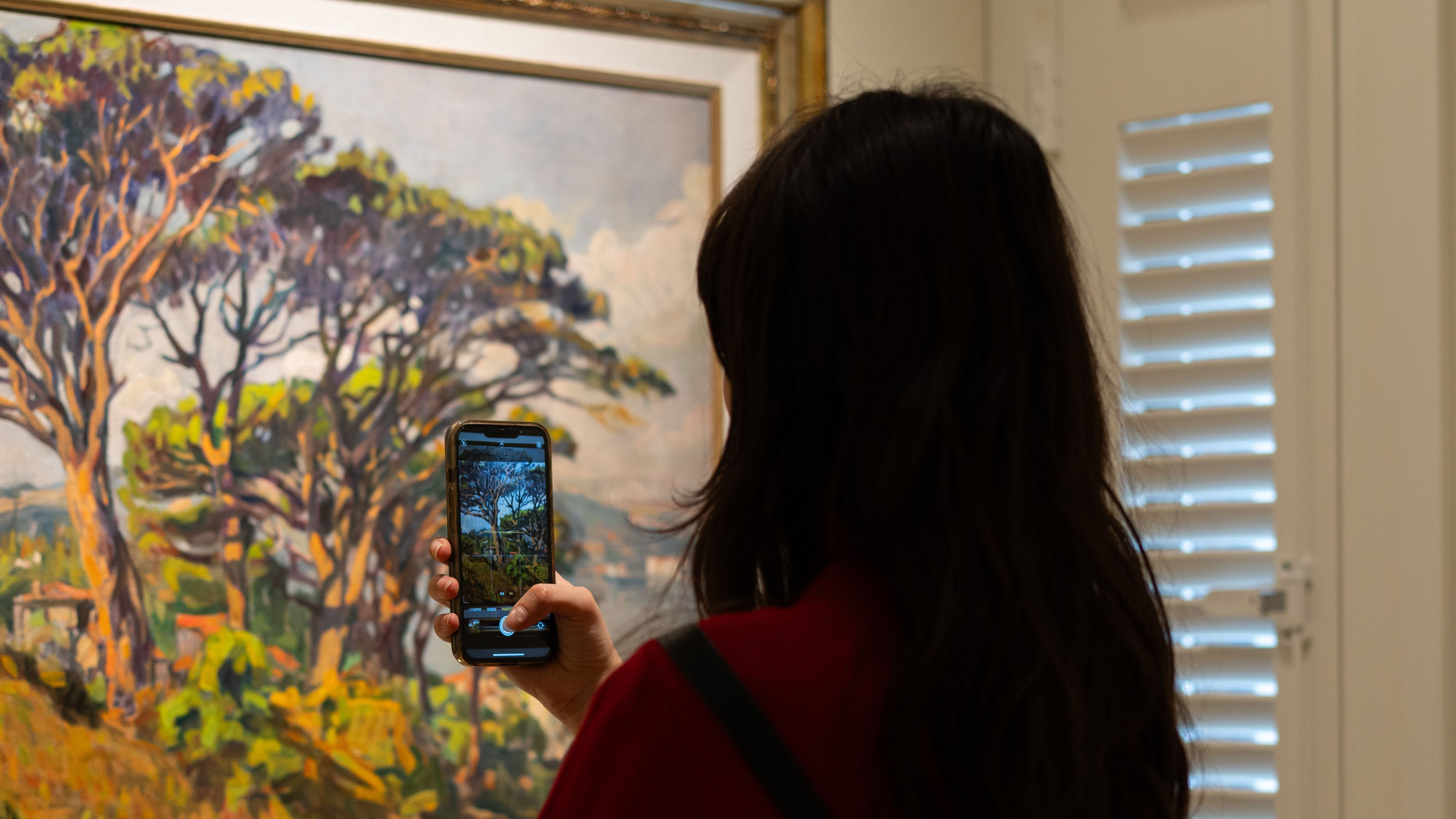 Besucherin nutzt den KulturKompass auf dem Smartphone vor einem Exponat im Museum